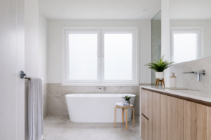White aluminium window, allowing ample natural light to flow into the bathroom. An equally impressive focal point to the large free-standing bathtub.