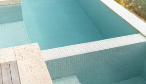 Outdoors stone pavers, perfectly compliment the custom pool tiles and aqua blue water