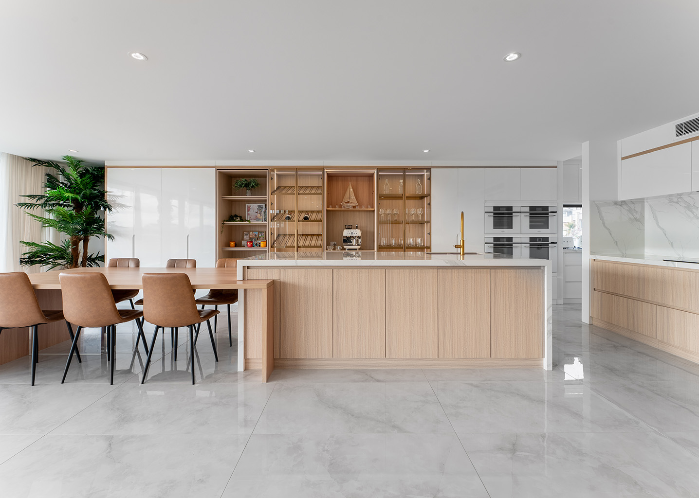 Contemporary, minimalism style kitchen boasting lifestyle concsious, custom cabinetry, island bench extending into a dining table for entertaining.